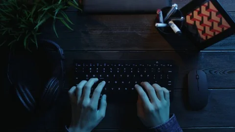 Overhead shot of man typing on keyboard and putting on headphones Stock Footage 81184508