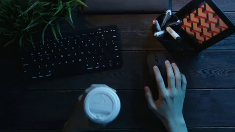 Overhead shot of man using computer mouse with cup of coffee in other hand Stock Footage 81166039