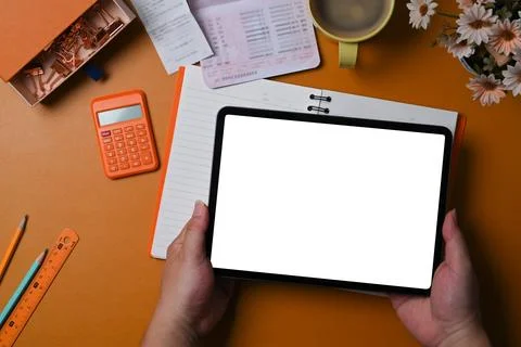 Overhead shot man using digital tablet and checking balance or costs. Stock Photos
