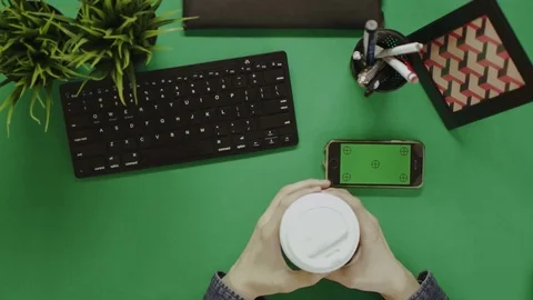 Overhead shot of man using his smartphone with green screen during coffee break Stock Footage 81219939