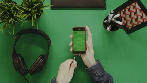 Overhead shot of man using his smartphone with green screen and putting on Stock Footage 81232142