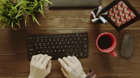 Overhead shot of man using keyboard and drinking tea Stock Footage 81173627