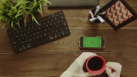 Overhead shot of man using smartphone with green screen and drinking coffee Stock Footage 81174362