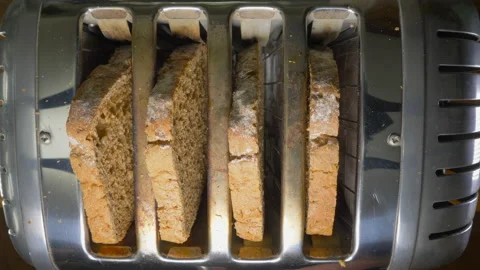 Overhead shot of a man's hands placing four bread slices into a toaster. Video stock 154735745
