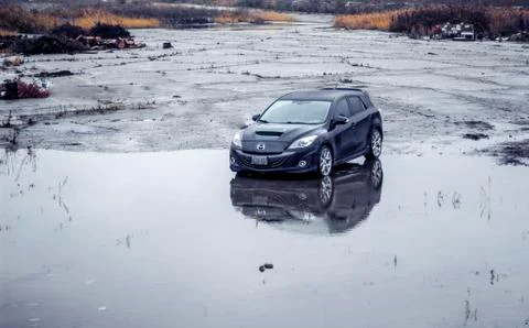 A overhead shot of a Mazdaspeed3 in an abandoned wet parking lot. Stock Photos