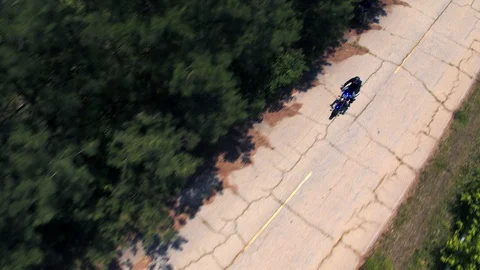 Overhead shot of motorcycle driving down country road Video stock 92319675