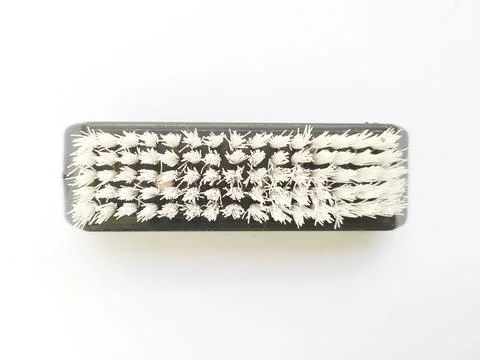 Overhead shot of a rectangular brush with stiff, offwhite bristles against a  库存照片