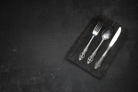 Overhead shot of silverware on black table with copy space. Stock Photos