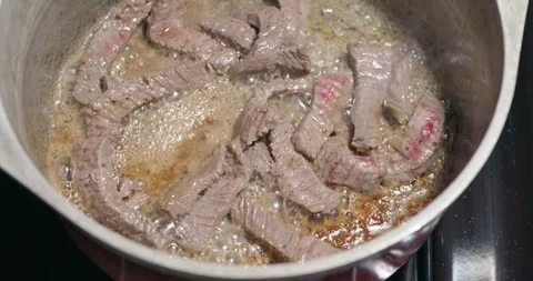Overhead Shot of Sliced Beef Strips Searing in a Hot Pot Stock-Footage 318754245