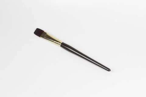 An overhead shot of a small size flat brush with a white-colored surface in t Stock Photos