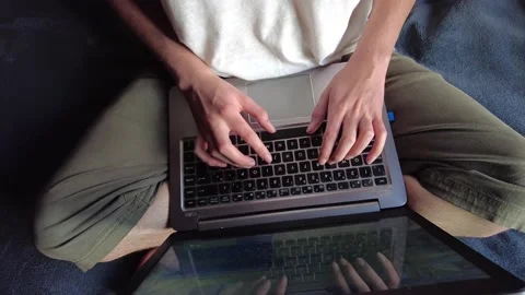 Overhead shot of a student or worker typing on a computer sitting on a bed Stock Footage 147361002