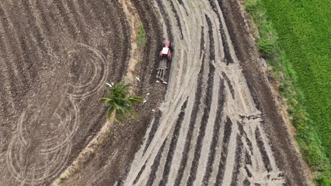Overhead shot of tractor preparing farmland with geometric patterns Stock Footage 340365344