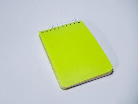 Overhead shot of vibrant yellow notepad with ring binding on a clean white .. Stock Photos