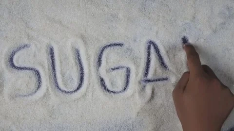 Overhead shot view of hand writing sugar word on sugar grains 库存影片 280747583