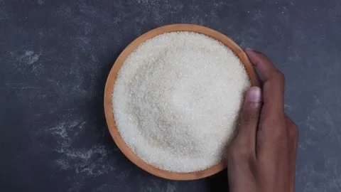 Overhead shot view of pick and putting down a bowl of sugar grain with hand 库存影片 281047774