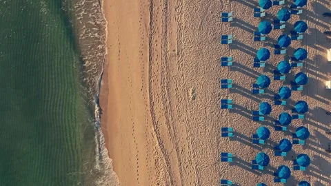 Overhead shot of waves breaking on beautiful tropical beach chairs and umbrellas Stock Footage 280507519