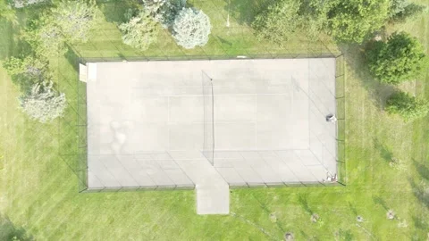 Overhead shot of a well-maintained tennis court surrounded by lush greenery Vidéo 331292003