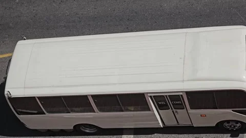 Overhead shot of a white mini-bus on an asphalt road 스톡 동영상 311883785