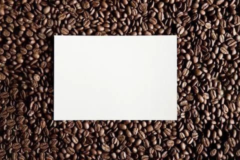 An overhead shot of a white rectangle in the middle of coffee beans great for 스톡 사진