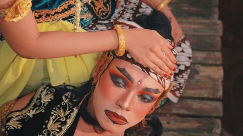 Overhead Shot of a Woman's Hands on a Man's Batik Headwrap Stock Footage 313469318
