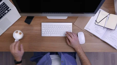 Overhead shot of worker drinking coffee while working at computer Stock Footage 70963085