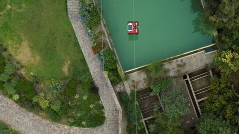 OVERHEAD TO SIDE SHOT OF CABLE CAR AERIAL TRAMWAY IT PASSES TROUGH A POOL 4K Stock Footage 102557645