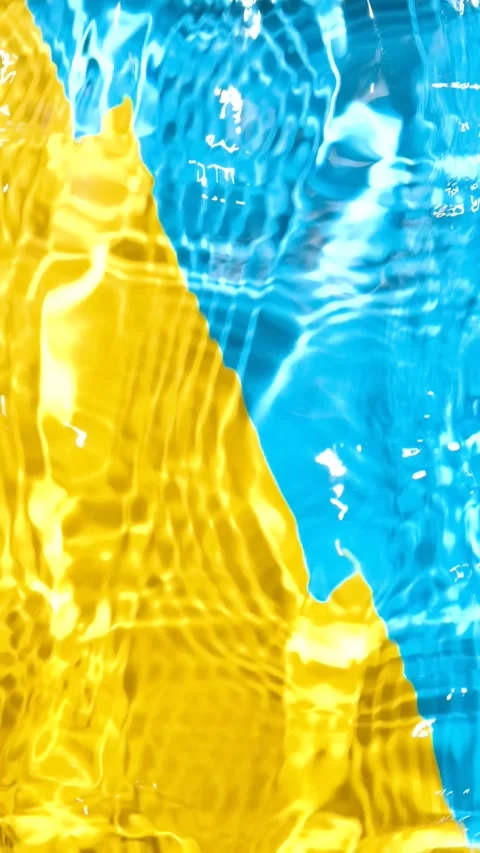 Overhead slow motion video of vibrant yellow blue liquid texture with shimmering Stock Footage 345657192