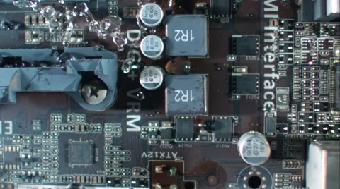 Overhead sweep across circuit board as water floods the electronics. Slow motion Stock Footage 64882805