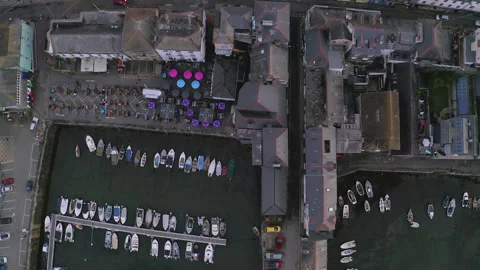 Overhead top-down aerial over Falmouth harbourside restaurants then boats in Stock Footage 144782299