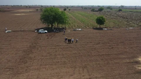 Overhead top down drone perspective capturing a team of workers in bright yellow Stock Footage 337191735