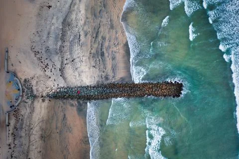 Overhead top-down drone view of jetty with waves breaking Stock Photos