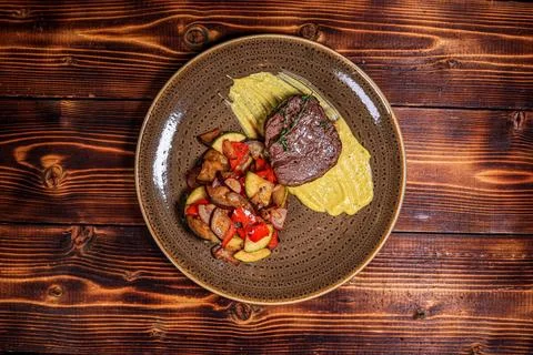 Overhead, top-down shot capturing a gourmet beef steak served with colorful r Stock Photos
