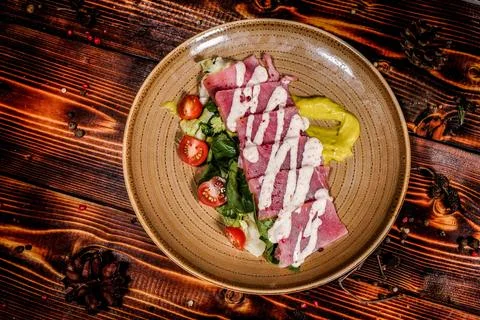 Overhead, top-down studio shot of the tuna tataki with lettuce, creamy sauce  Fotos Stock