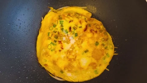 Overhead top down view of cooking an omelette with crispy bacon and sliced .. 動画素材 318129836