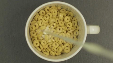 Overhead Top View of cereal rings with Milk falling in bowl in slow motion Stock Footage 130985933