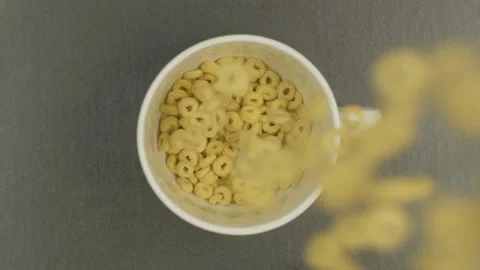 Overhead Top View of cereal rings falling in bowl in slow motion Breakfast 4K Video stock 130985970