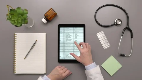 Overhead Top View Of Doctor Examining Medical Report On Digital Tablet Video stock 79649482