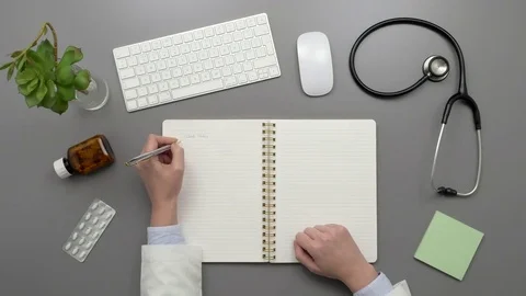 Overhead Top View Of Doctor Writing In Notebook At Desk Stock Footage 79649504