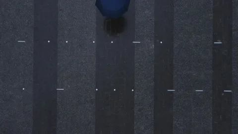 Overhead top view man with blue umbrella walking pass Stock Footage 150043229