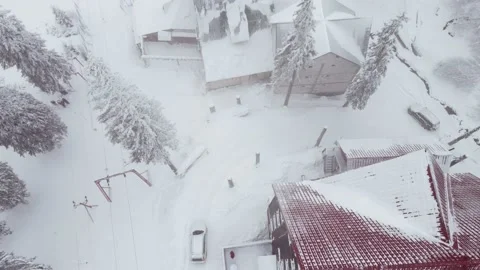 Overhead top view of snow storm car moves down by hill near building Video stock 162443238