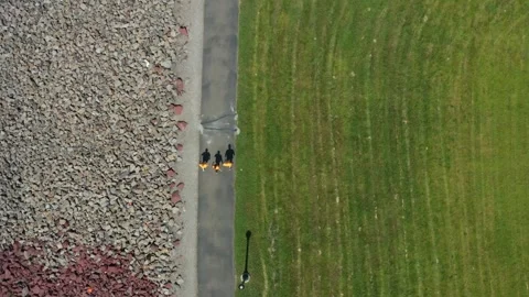 Overhead Tracking Shot of 3 People Walking on Path Stock Footage 273500586