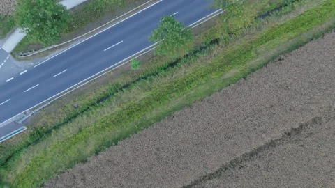 Overhead tracking view of a two-lane country road through fields 스톡 동영상 340159240