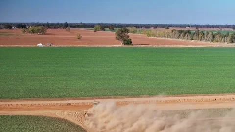 Overhead of tractor pulling a road grader along a dirt farm road with lost Stock Footage 276971449