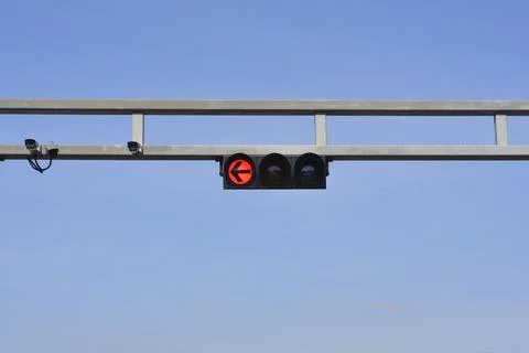 Overhead traffic light with red arrow signal and security cameras Stock Photos