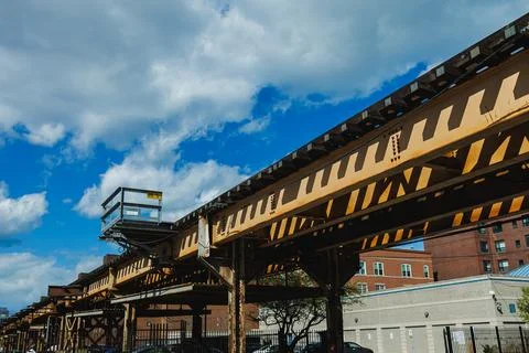 Overhead train tracks stretch across an urban landscape with a blue sky and.. Foto stock