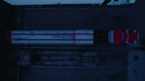 Overhead Twilight Drone Shot of Red Semi Truck with Flatbed step deck Trailer Stock Footage 311175050