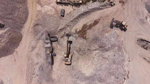 Overhead view of an active quarry or mining site with heavy machinery including Stock Footage 336741690