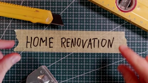 Overhead view of applying HOME RENOVATION tape near scraper and wrench. Stock Footage 337816232