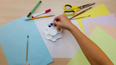 Overhead View of Artist Squeezing Blue Acrylic Paint onto White Palette Stock Footage 327121421