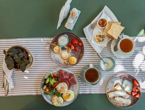 Overhead view of assorted breakfast plates with eggs syrniki cottage cheese Stock Photos